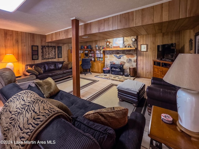 tiled living room with a wood stove, wooden walls, and a textured ceiling