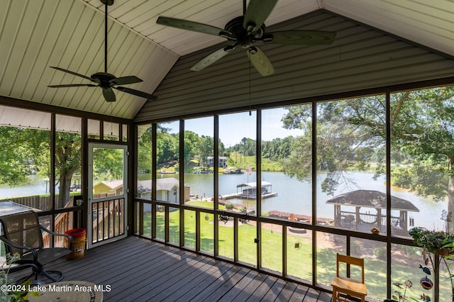 unfurnished sunroom with ceiling fan, a water view, and vaulted ceiling