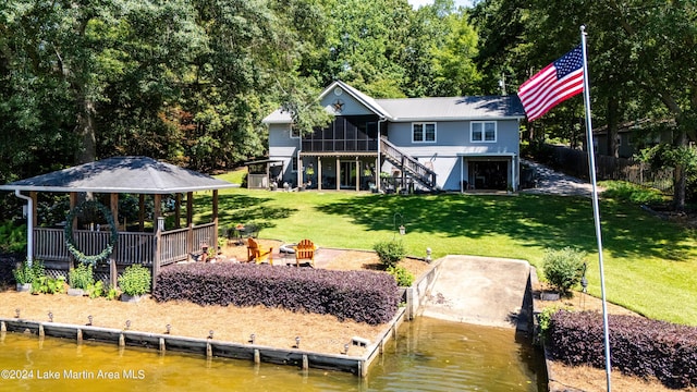 back of property featuring a gazebo, a yard, a water view, and a sunroom