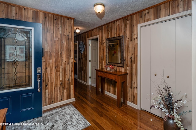 foyer entrance featuring ornamental molding, dark wood-type flooring, and wooden walls