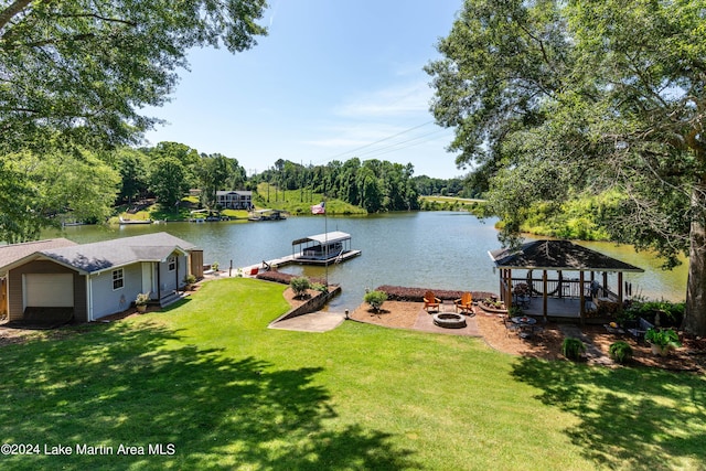 view of dock with a fire pit, a water view, and a lawn