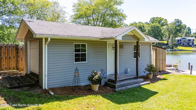 exterior space with a water view, a front lawn, and an outdoor structure