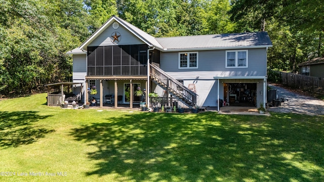 rear view of house featuring a patio area, a sunroom, and a yard