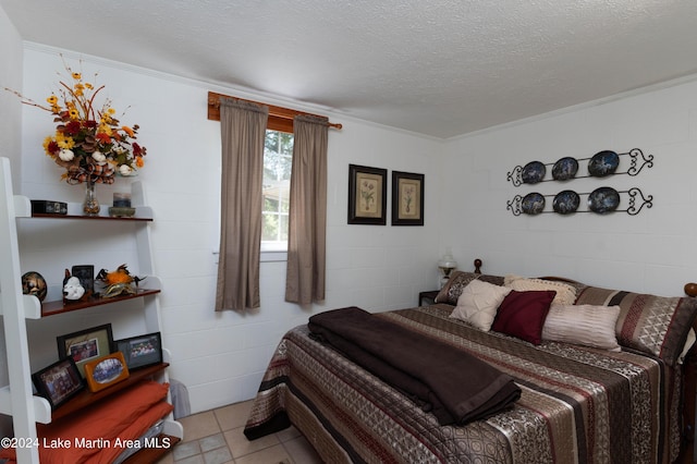 bedroom featuring a textured ceiling, crown molding, and light tile patterned flooring