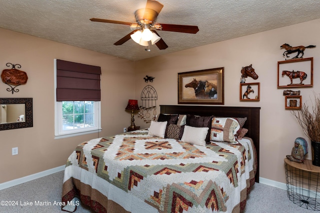 bedroom featuring ceiling fan, a textured ceiling, and light carpet