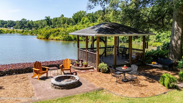 view of patio with a gazebo, a deck with water view, and a fire pit