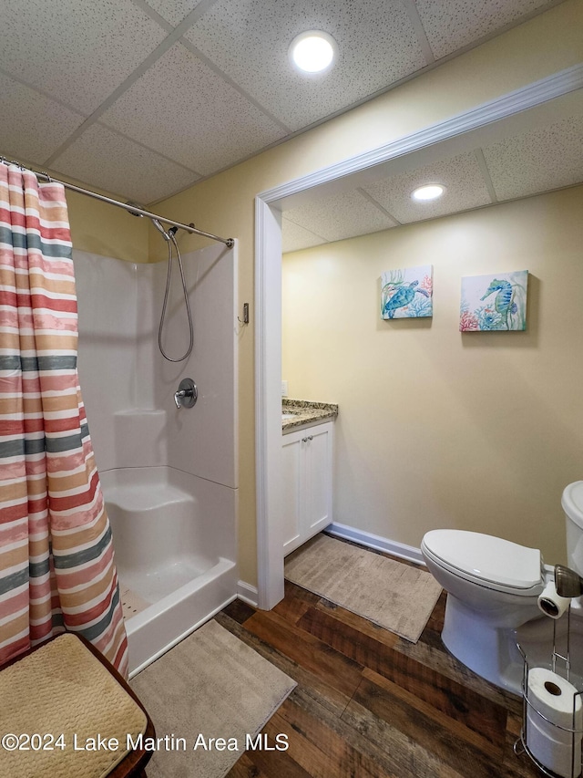 bathroom with vanity, hardwood / wood-style flooring, walk in shower, and a paneled ceiling