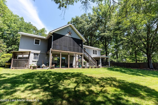 rear view of property with a sunroom and a yard