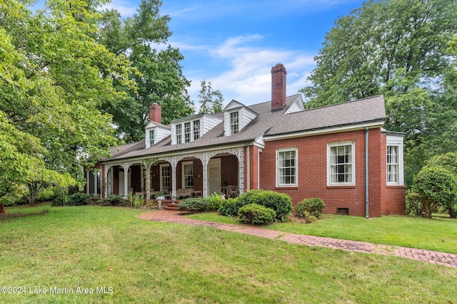 cape cod house with a front lawn and covered porch