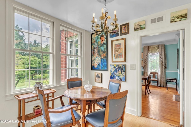 dining room featuring a chandelier, a healthy amount of sunlight, and light hardwood / wood-style flooring