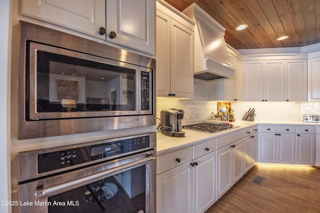 1220 Willow Way E, Alexander City, AL 35010 - kitchen featuring white cabinetry, tasteful backsplash, premium range hood, wood ceiling, and appliances with stainless steel finishes