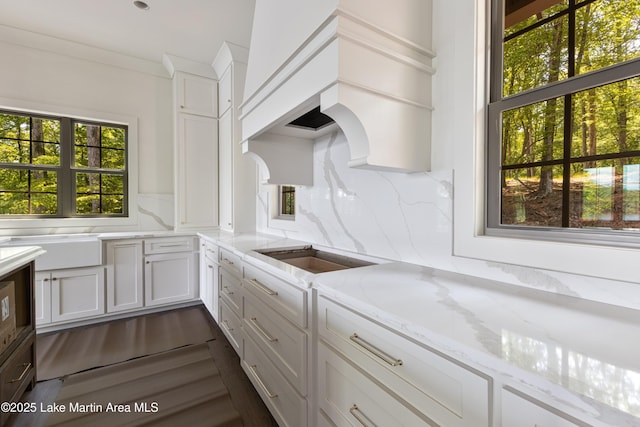 kitchen featuring light stone countertops and white cabinetry