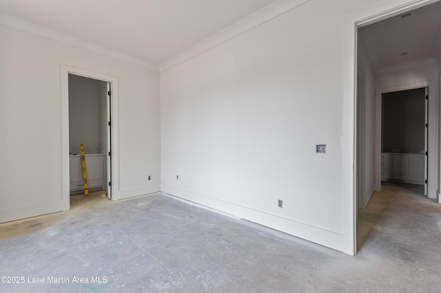 spare room with baseboards, crown molding, and unfinished concrete flooring