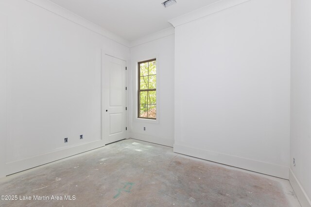 empty room featuring baseboards, ornamental molding, unfinished concrete flooring, and visible vents