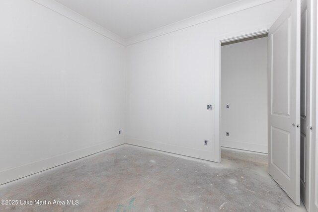 unfurnished room featuring baseboards, ornamental molding, and unfinished concrete floors