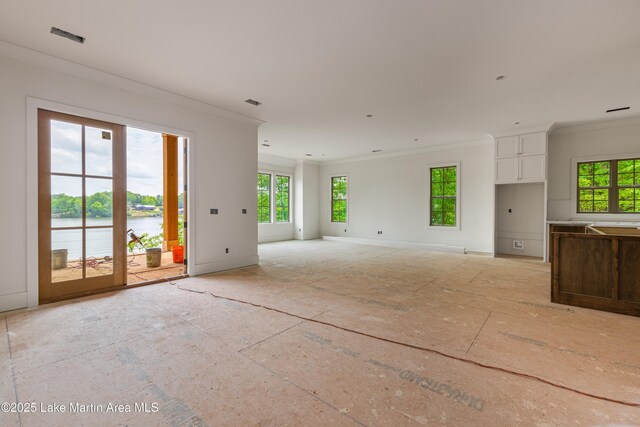 unfurnished living room featuring crown molding, a water view, baseboards, and a wealth of natural light