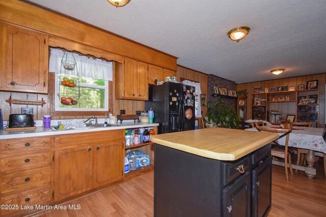 230 Lorena Dr, Alexander City, AL 35010 - kitchen featuring brown cabinetry, light countertops, black refrigerator with ice dispenser, and light wood-style floors