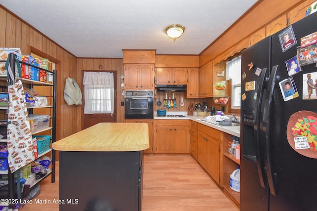 230 Lorena Dr, Alexander City, AL 35010 - kitchen featuring a center island, a sink, under cabinet range hood, black appliances, and light wood-style flooring