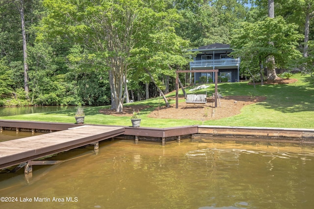 view of dock featuring a water view and a yard