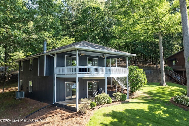 rear view of house with ceiling fan, a yard, central air condition unit, a balcony, and a patio area