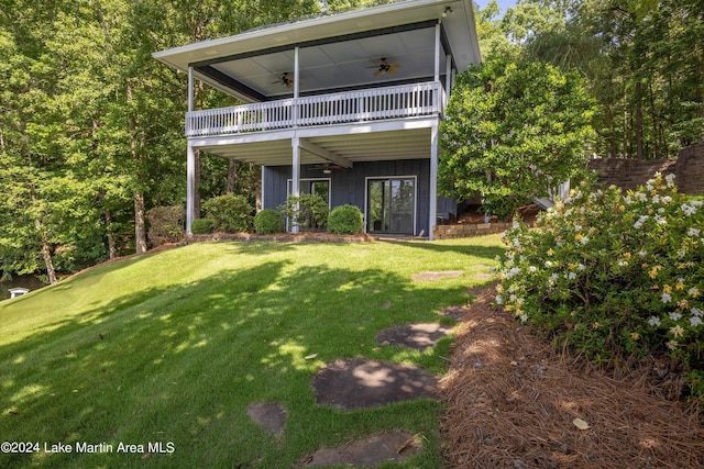 view of front facade featuring a front lawn, a balcony, and ceiling fan