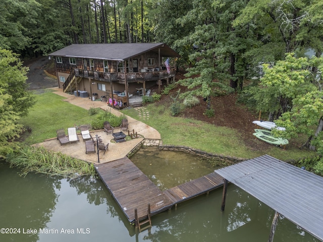 view of dock featuring a lawn, a deck with water view, central air condition unit, and a patio