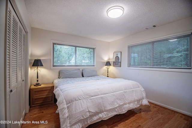 bedroom featuring wood-type flooring and a textured ceiling