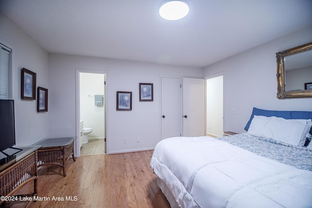 bedroom with light hardwood / wood-style flooring and ensuite bath