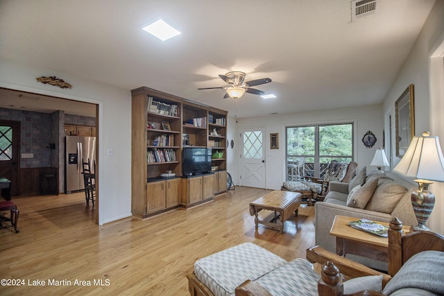 living room featuring ceiling fan and light hardwood / wood-style floors