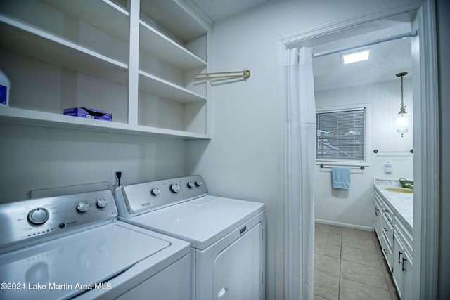 laundry room featuring washer and clothes dryer, light tile patterned flooring, and sink