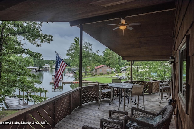 wooden terrace with ceiling fan and a water view