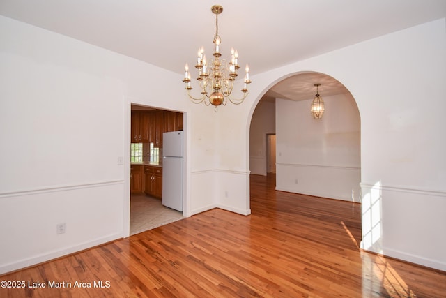 1647 Timber Trl, Alexander City, AL 35010 - unfurnished dining area featuring light wood finished floors, baseboards, arched walkways, and a notable chandelier
