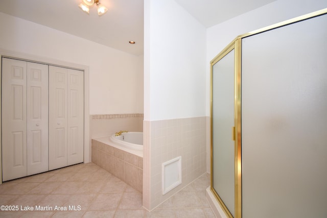 1647 Timber Trl, Alexander City, AL 35010 - full bathroom featuring a closet, a shower stall, a garden tub, and tile patterned flooring