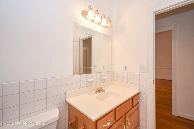 1647 Timber Trl, Alexander City, AL 35010 - half bathroom featuring tile walls, toilet, vanity, and wood finished floors