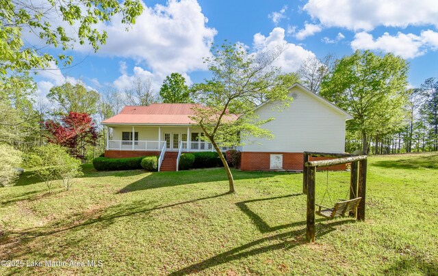 1647 Timber Trl, Alexander City, AL 35010 - view of front facade featuring french doors, a front lawn, a porch, metal roof, and brick siding