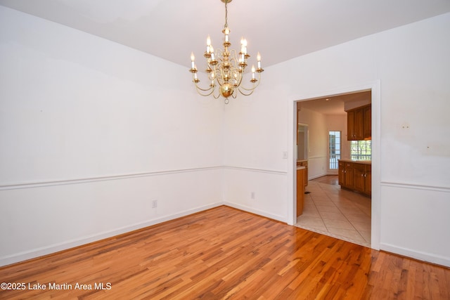 1647 Timber Trl, Alexander City, AL 35010 - empty room with baseboards, light wood-style floors, and a chandelier