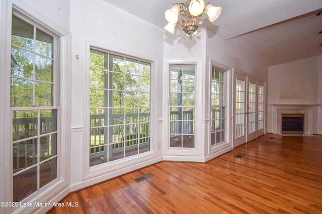 1647 Timber Trl, Alexander City, AL 35010 - interior space with a fireplace, wood-type flooring, visible vents, and an inviting chandelier