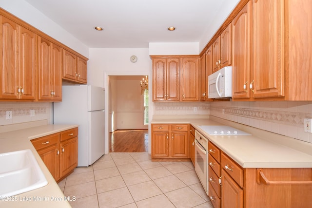1647 Timber Trl, Alexander City, AL 35010 - kitchen featuring a sink, backsplash, white appliances, light countertops, and light tile patterned floors