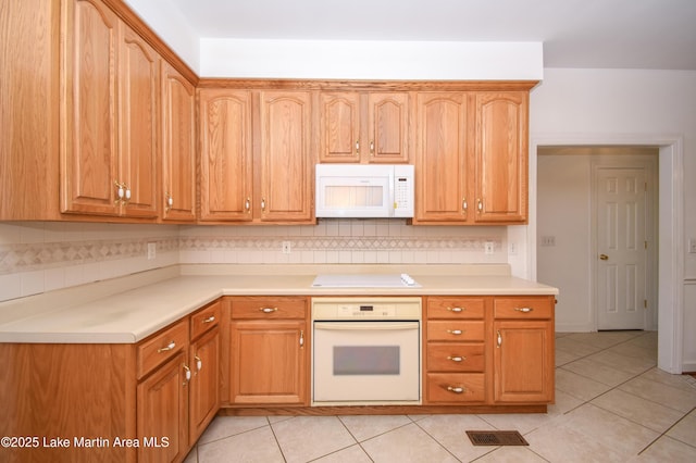 1647 Timber Trl, Alexander City, AL 35010 - kitchen with tasteful backsplash, light countertops, white appliances, and light tile patterned floors