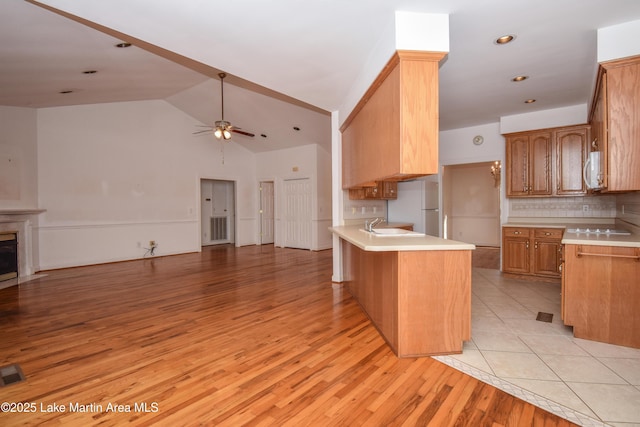 1647 Timber Trl, Alexander City, AL 35010 - kitchen with light countertops, a ceiling fan, white appliances, a peninsula, and open floor plan