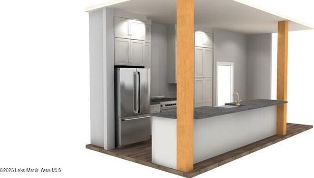 kitchen with dark countertops, a sink, and freestanding refrigerator