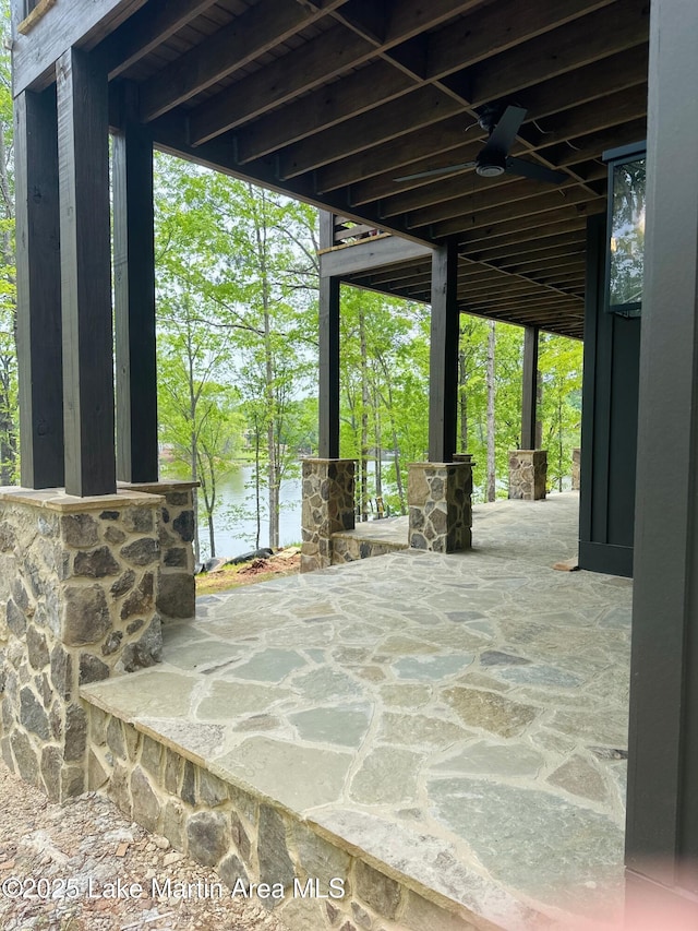 view of patio / terrace featuring ceiling fan and a water view