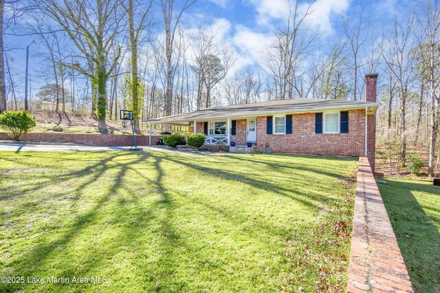 241 Warrior Rd, Alexander City, AL 35010 - view of front of house featuring a front lawn, a porch, a carport, brick siding, and a chimney