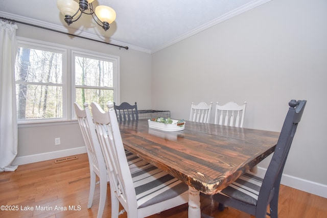241 Warrior Rd, Alexander City, AL 35010 - dining room featuring visible vents, a chandelier, crown molding, and light wood-style flooring
