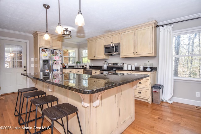 241 Warrior Rd, Alexander City, AL 35010 - kitchen featuring light wood finished floors, light brown cabinets, crown molding, appliances with stainless steel finishes, and a kitchen breakfast bar