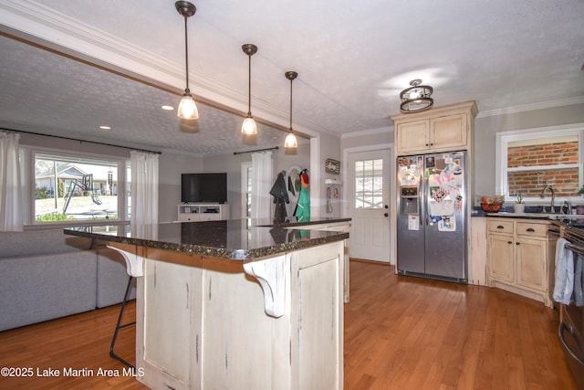 241 Warrior Rd, Alexander City, AL 35010 - kitchen featuring a breakfast bar area, light wood-style flooring, ornamental molding, stainless steel fridge, and open floor plan