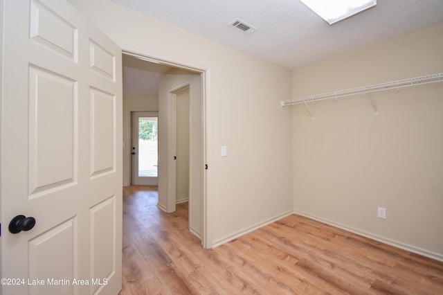 interior space with a textured ceiling and light hardwood / wood-style flooring