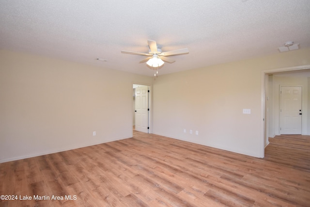 unfurnished room with a textured ceiling, light hardwood / wood-style flooring, and ceiling fan