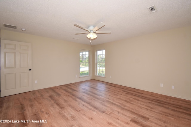 spare room featuring ceiling fan, a textured ceiling, and light wood-type flooring