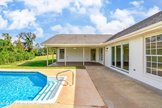 view of pool with ceiling fan, a patio area, and a yard